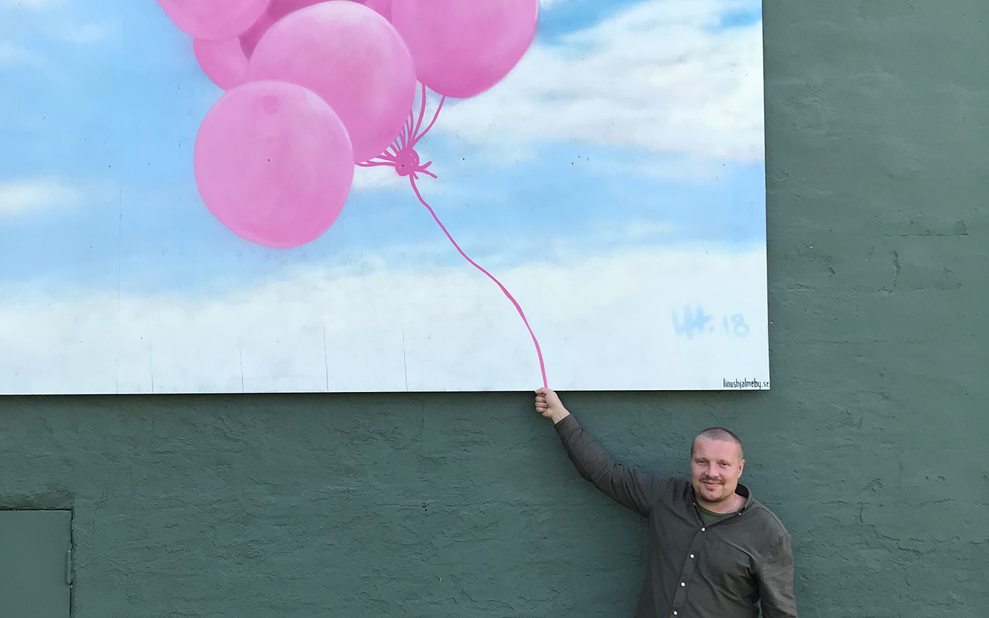 Graffiti-konstnären Linus Hjälmeby framför ett av hans konstverk.